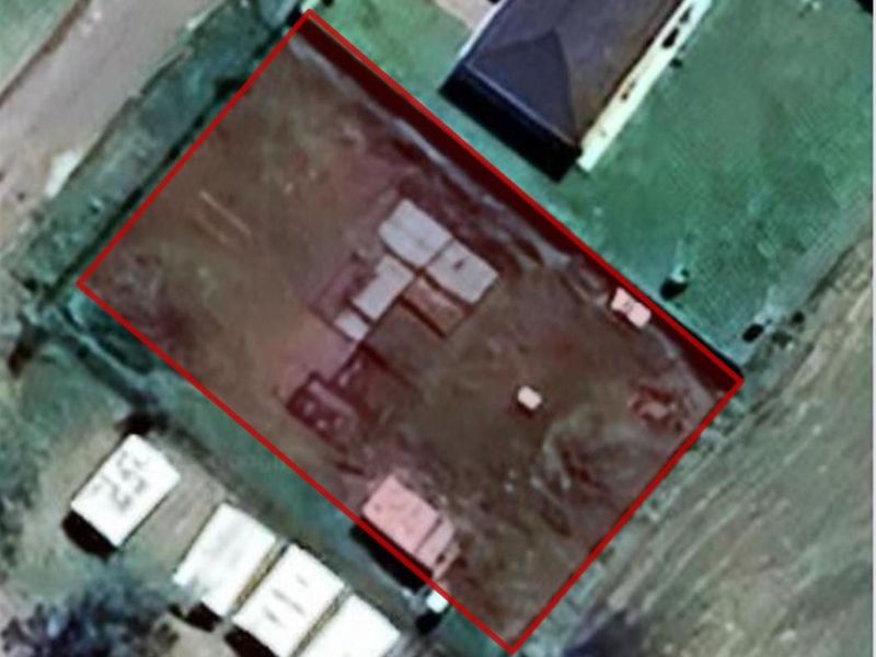 An aerial view of a vacant residential plot with boundary lines highlighted, showing the cleared land ready for development.