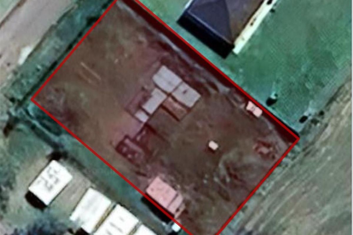 An aerial view of a vacant residential plot with boundary lines highlighted, showing the cleared land ready for development.