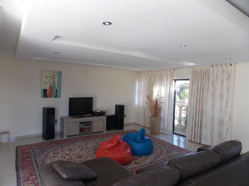 Spacious living room featuring recessed ceiling lighting and large sliding glass doors providing access to an outdoor balcony area.