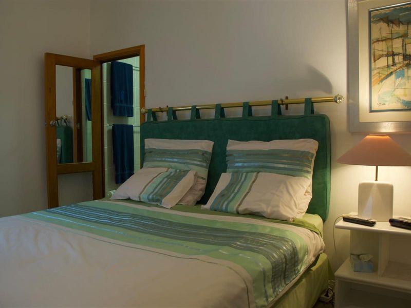 A bedroom featuring a headboard and direct access to an adjoining bathroom.
