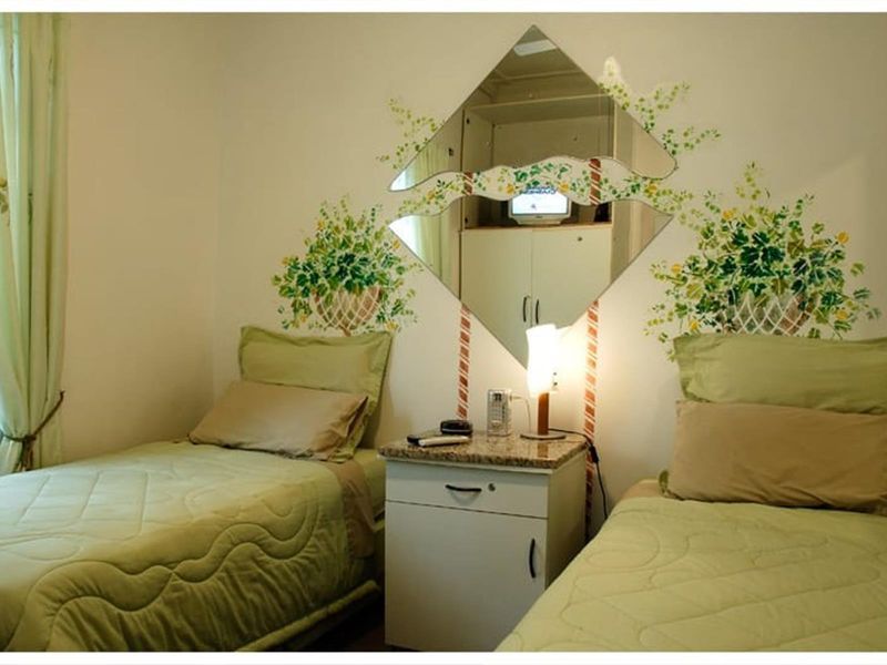 A bedroom featuring a built-in cupboard and decorative wall murals.