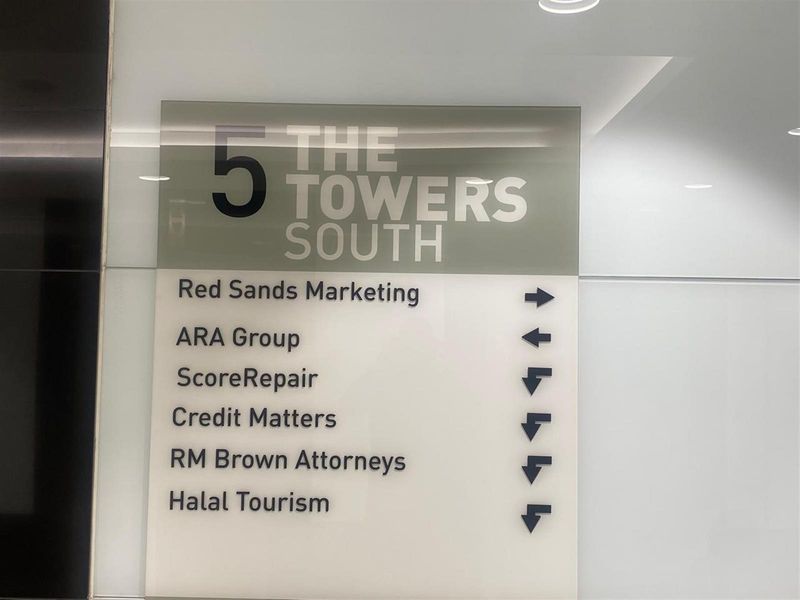 A clear building directory sign located in the lobby area of The Towers South, listing various office tenants.