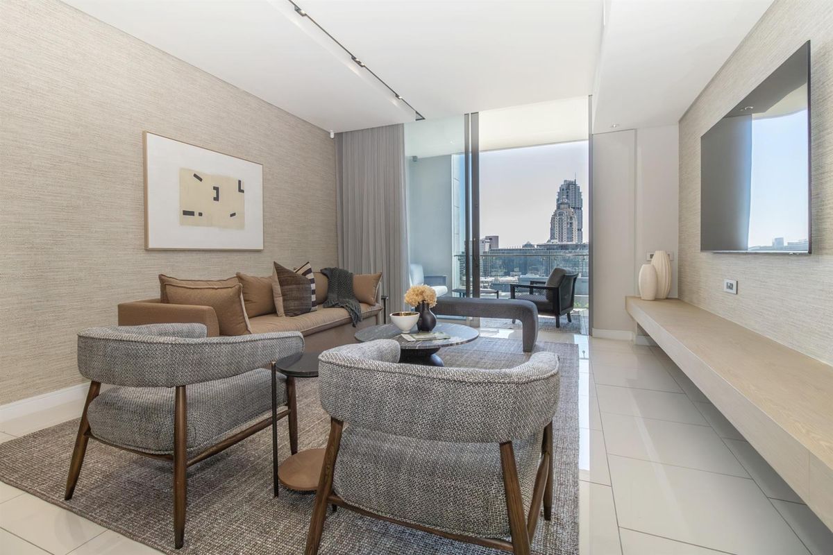 Modern living room featuring tiled flooring, textured wallpaper, a floating media console, and floor-to-ceiling sliding glass doors leading to a balcony with city views.