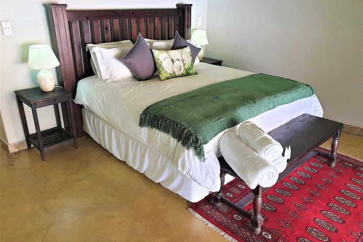 A well-maintained bedroom featuring polished concrete flooring and a built-in wooden headboard, offering a clean and functional space.