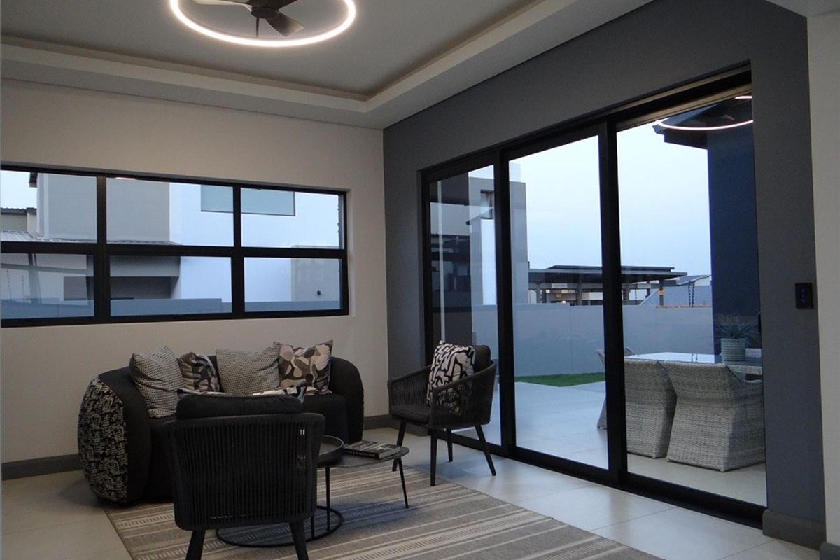 Modern living room featuring large sliding glass doors that provide seamless access to the outdoor patio area and ample natural light.