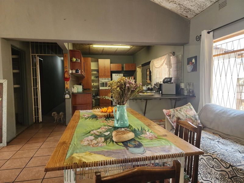 Open plan living and kitchen area featuring tiled floors, built-in cabinetry, and an integrated oven, with potential for cosmetic updates to the ceiling.