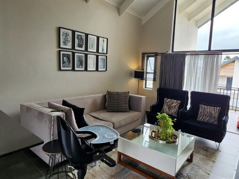 Spacious open-plan living area featuring high vaulted ceilings, large windows for natural light, and a modern kitchen with granite countertops.