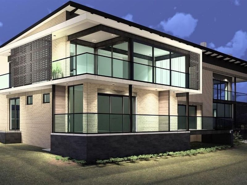 A modern two-story residential property featuring contemporary brickwork, expansive glass sliding doors, and sleek glass-railed balconies, captured at twilight.