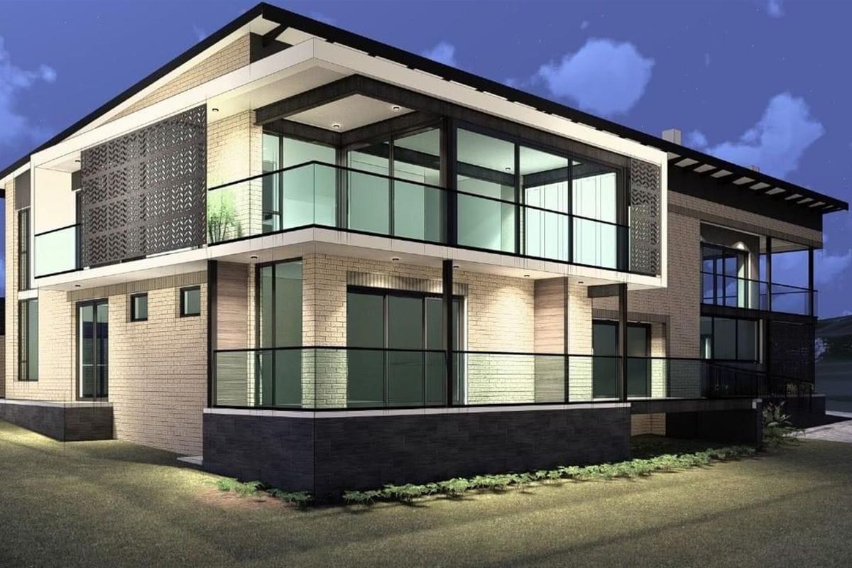 A modern two-story residential property featuring contemporary brickwork, expansive glass sliding doors, and sleek glass-railed balconies, captured at twilight.