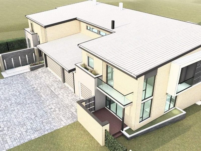 An aerial view of a modern two-story house featuring a paved driveway, integrated garage, and contemporary architectural design with glass balcony railings.