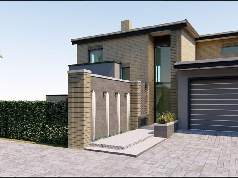 Modern architectural front elevation featuring a brick facade, integrated water feature, paved driveway, and a double garage.