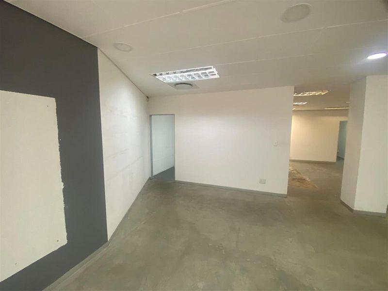 An empty, open-plan retail space featuring concrete flooring, recessed lighting, and neutral painted walls, ready for custom fit-out and interior design.