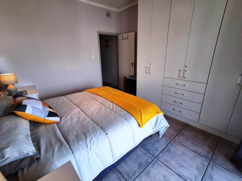 A bedroom featuring built-in cupboards and tiled flooring, providing functional storage and a neutral base for interior design.
