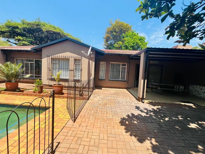 Rear view of the property featuring a paved patio area, swimming pool with safety fencing, and a covered outdoor entertainment space.