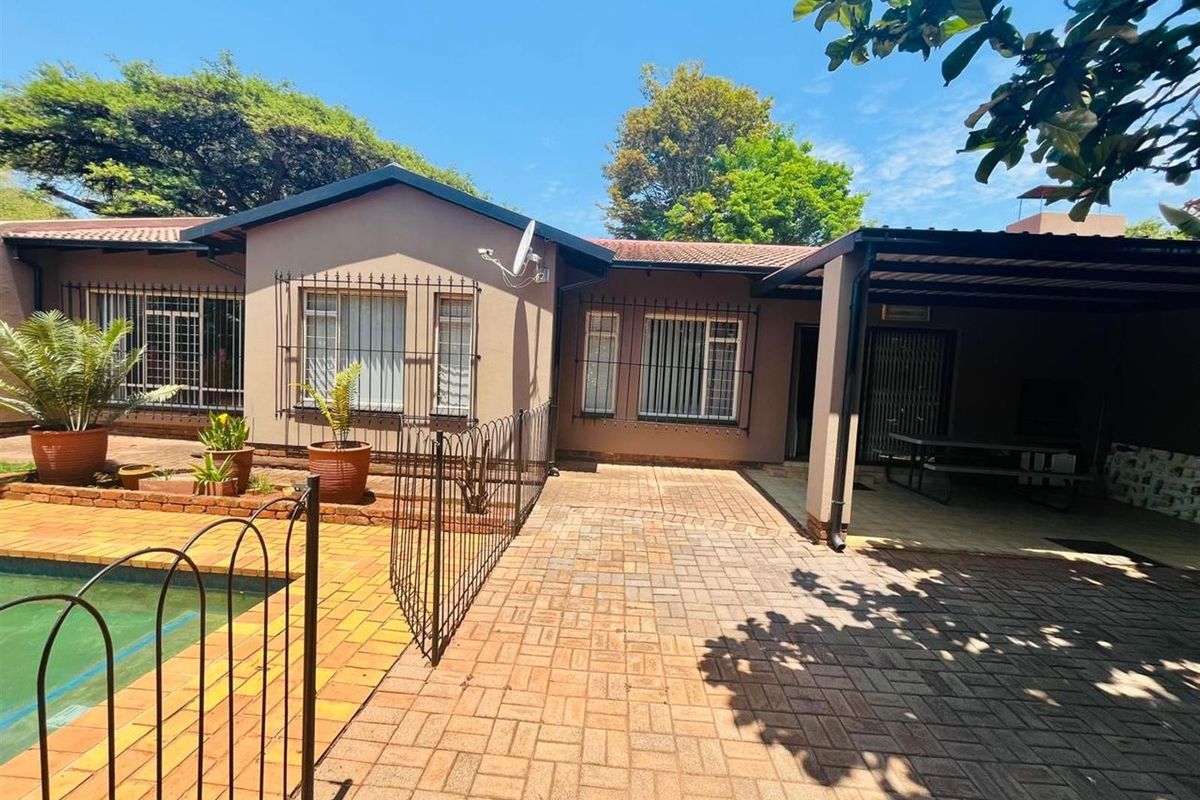 Rear view of the property featuring a paved patio area, swimming pool with safety fencing, and a covered outdoor entertainment space.