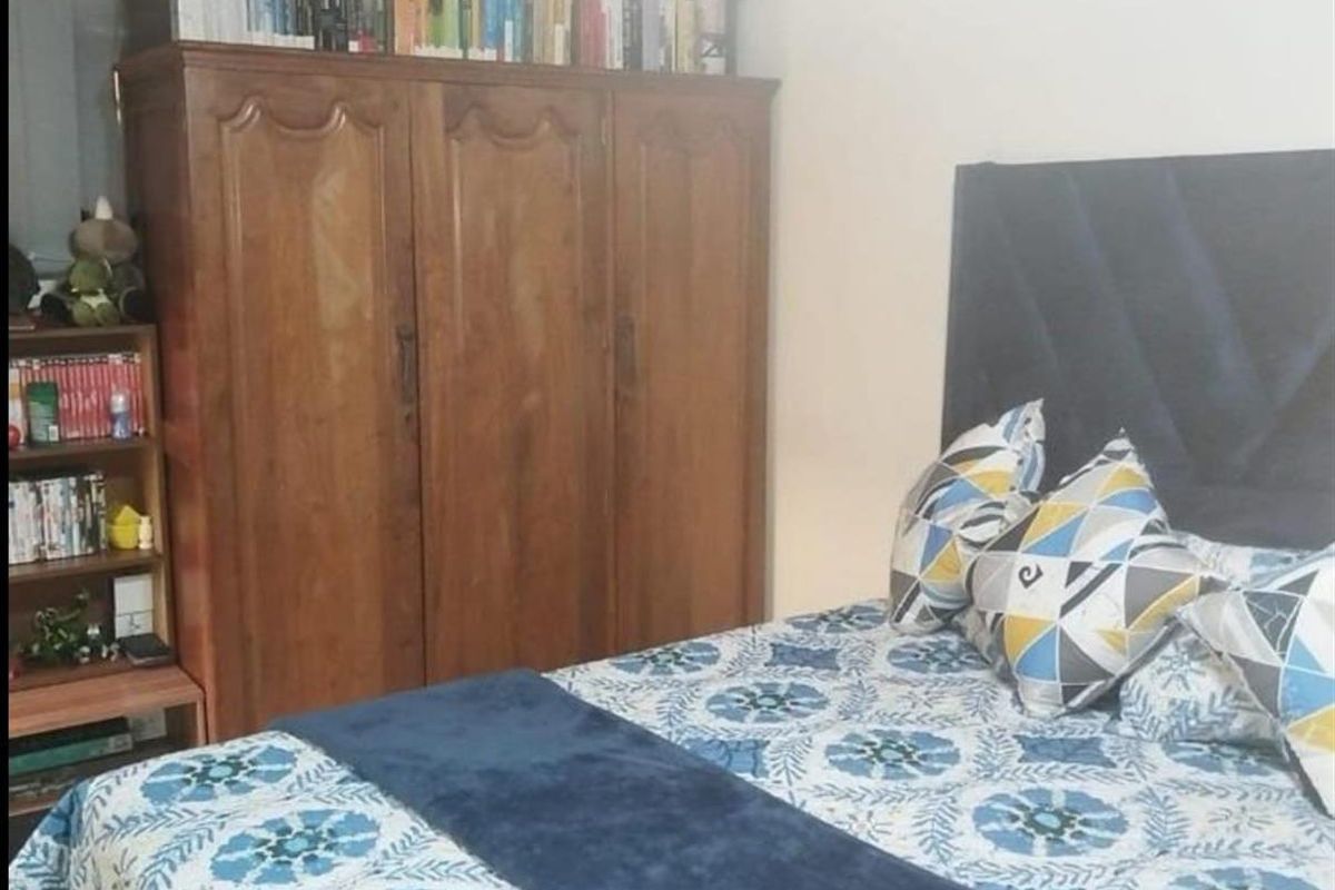 A bedroom featuring wood-paneled ceiling details and tiled flooring, providing a functional sleeping space within the farm property.