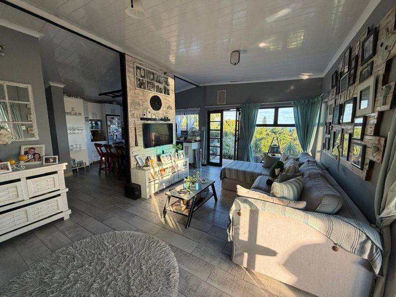 Open-plan living area featuring tiled floors, a timber-look feature wall, and a tongue and groove ceiling, with direct access to the outdoor space.