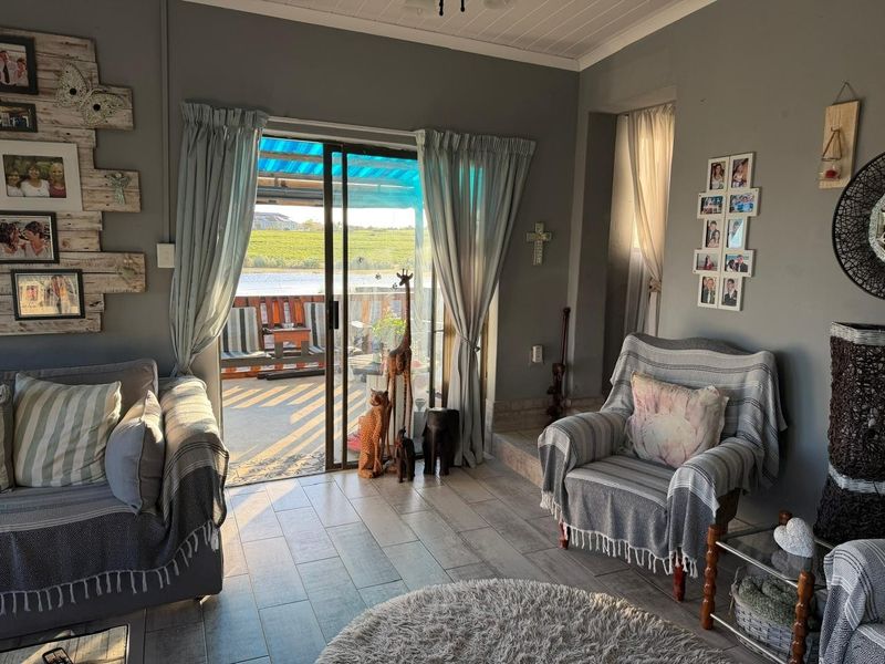 A living room featuring tiled flooring and a sliding glass door that provides access to an outdoor patio area.
