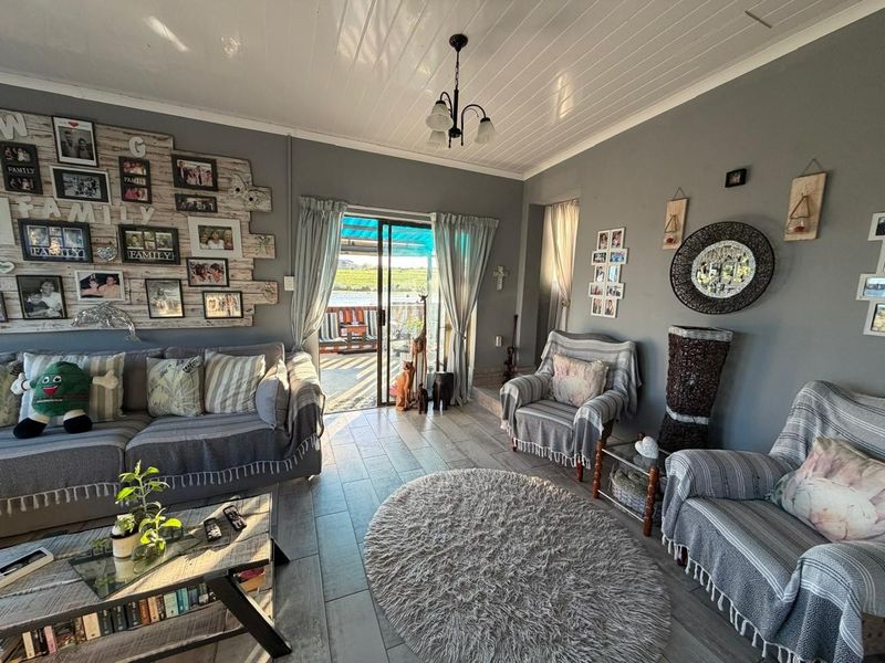 A comfortable living room featuring tiled flooring, a tongue and groove ceiling, and a sliding glass door providing access to the outdoor patio area.