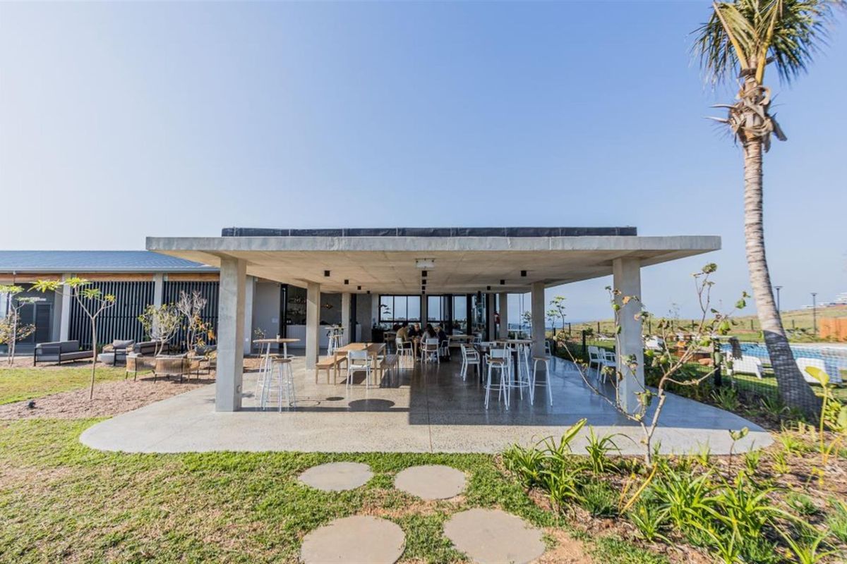 A spacious covered patio area featuring a concrete roof structure and polished concrete flooring, ideal for outdoor entertaining and relaxation.