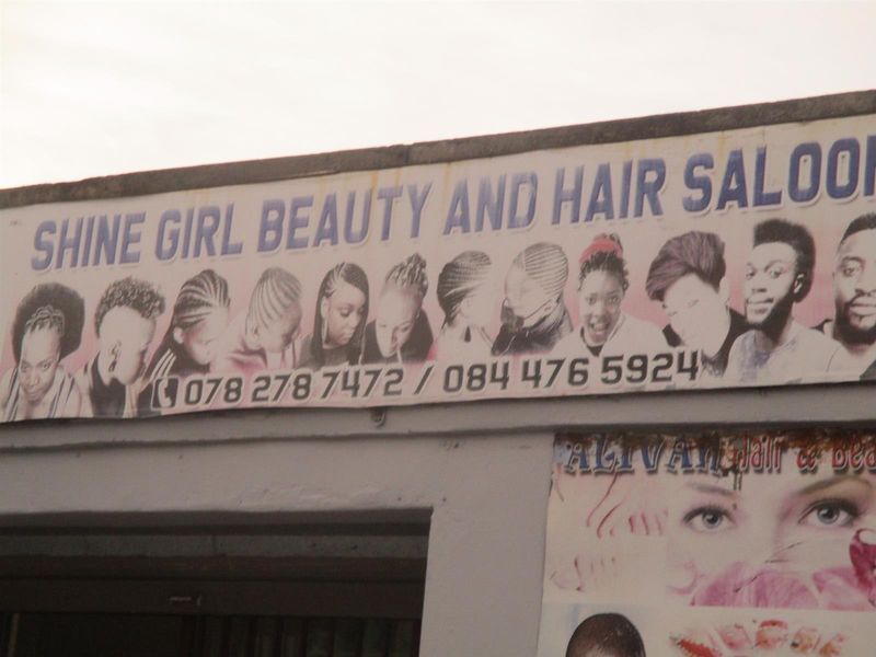 Exterior view of a commercial property featuring prominent signage for a beauty and hair salon.