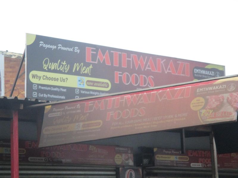 Commercial storefront featuring prominent business signage and branding for a meat supplier.
