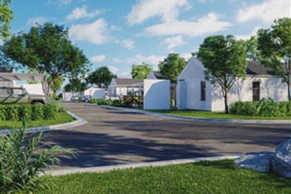 A street view of a residential development featuring paved roads, curbs, and modern residential buildings set within a landscaped environment.