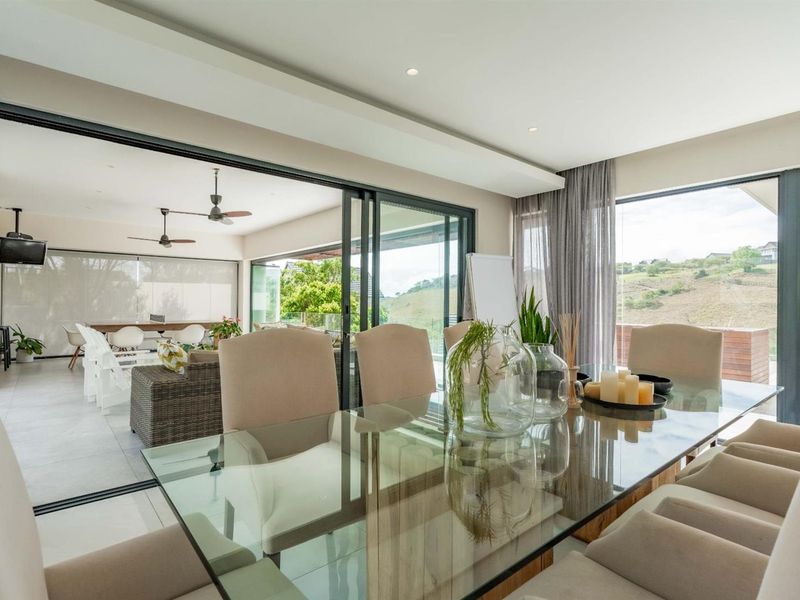 Spacious open-plan dining area featuring large sliding glass doors that provide seamless indoor-outdoor flow to the covered patio and scenic views.