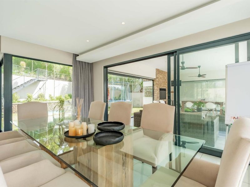 Bright and modern dining area featuring large sliding glass doors that provide seamless access to the outdoor patio and garden.