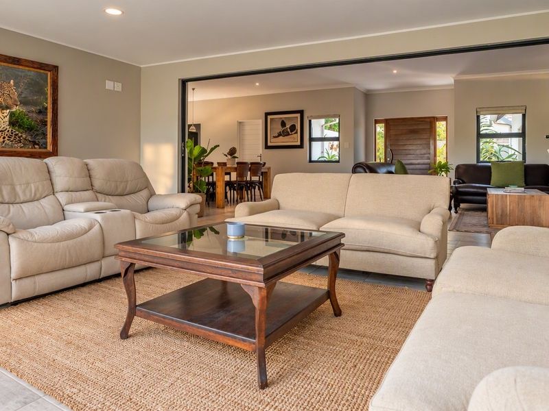 Spacious open-plan living area featuring large stacking doors that provide seamless indoor-outdoor flow, complemented by neutral tones and recessed lighting.