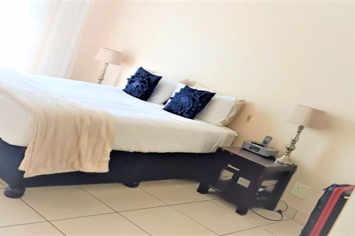 A bedroom featuring tiled flooring and neutral wall finishes, providing a functional sleeping space.