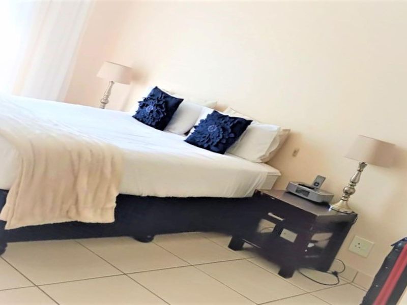 A bedroom featuring tiled flooring and neutral wall finishes, providing a functional sleeping space.