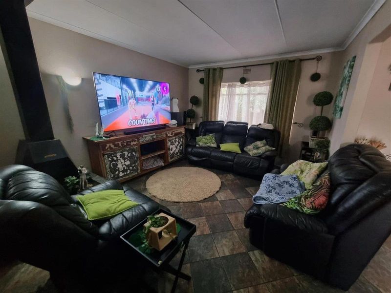 A comfortable living room featuring a built-in fireplace, tiled flooring, and large windows that provide natural light.