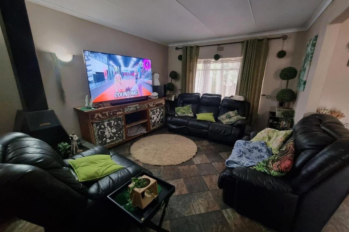 A comfortable living room featuring a built-in fireplace, tiled flooring, and large windows that provide natural light.
