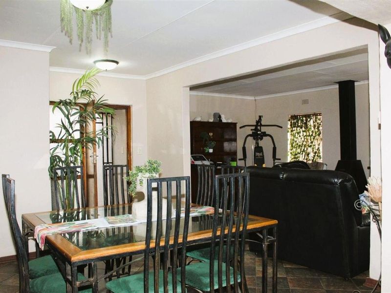 Open plan dining and living area featuring tiled flooring and a built-in fireplace, creating a functional and connected living space.
