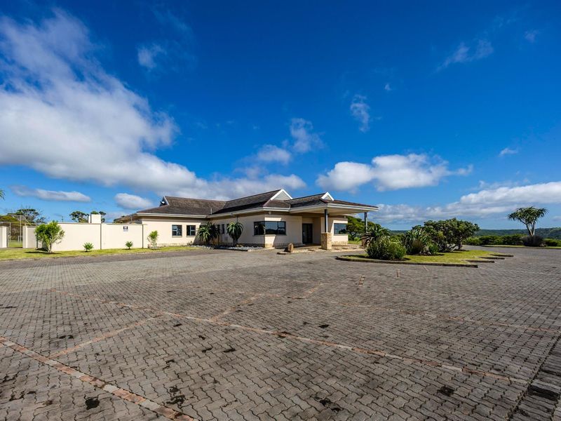Front exterior view of the residential property featuring a paved driveway, landscaped garden, and a covered entrance porch.