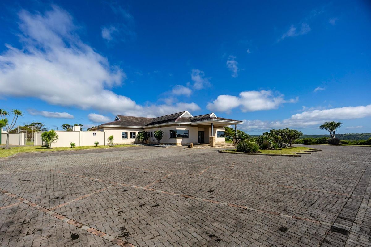 Front exterior view of the residential property featuring a paved driveway, landscaped garden, and a covered entrance porch.