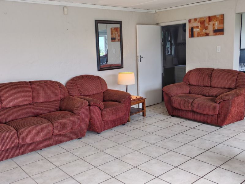 Open plan living area featuring tiled flooring and direct access to an adjoining kitchen space.