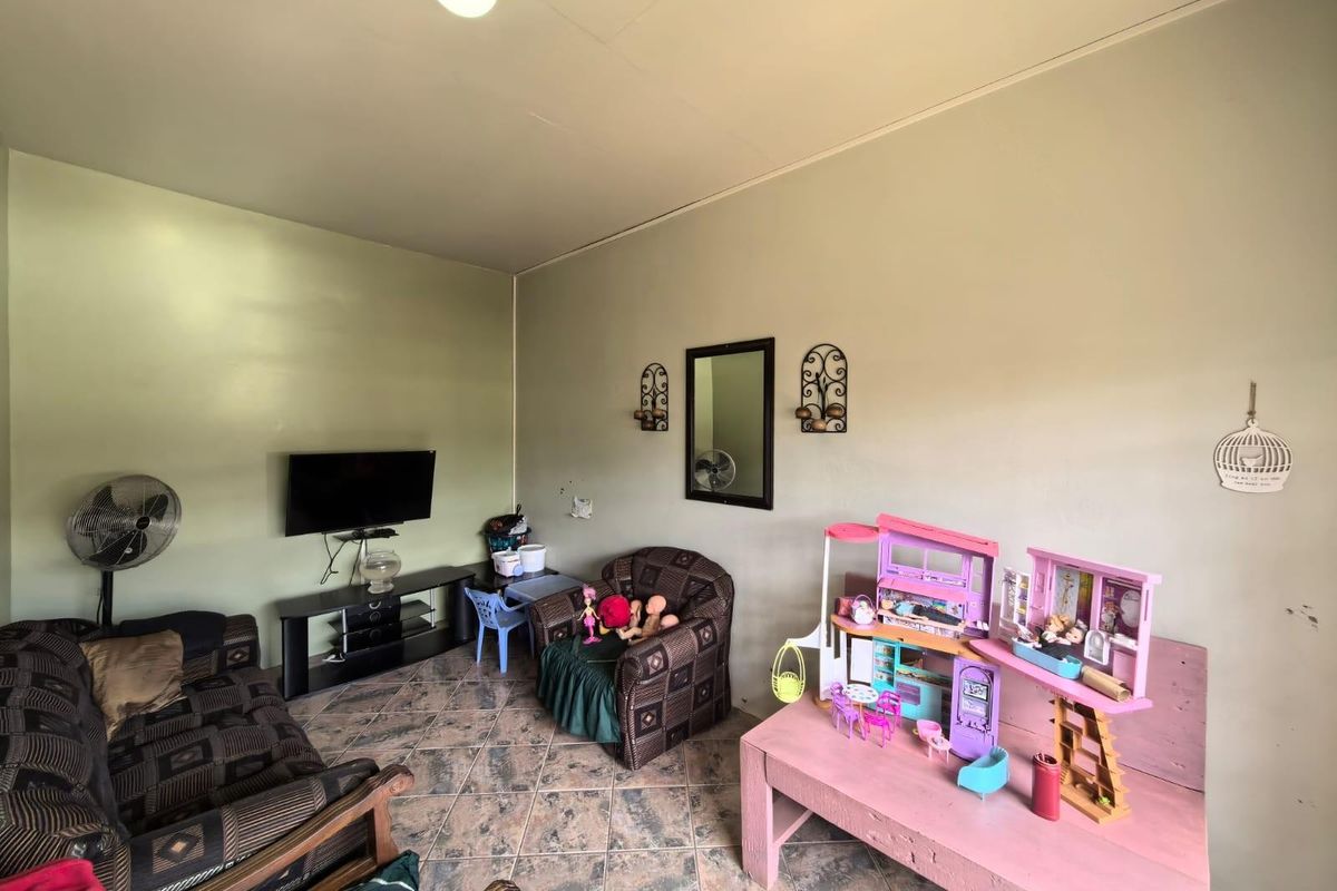 A living room featuring tiled flooring and neutral wall finishes, providing a functional space for daily living.