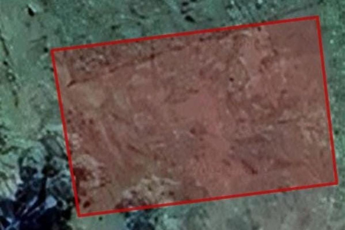 An aerial satellite view highlighting the boundaries of the vacant residential land plot.