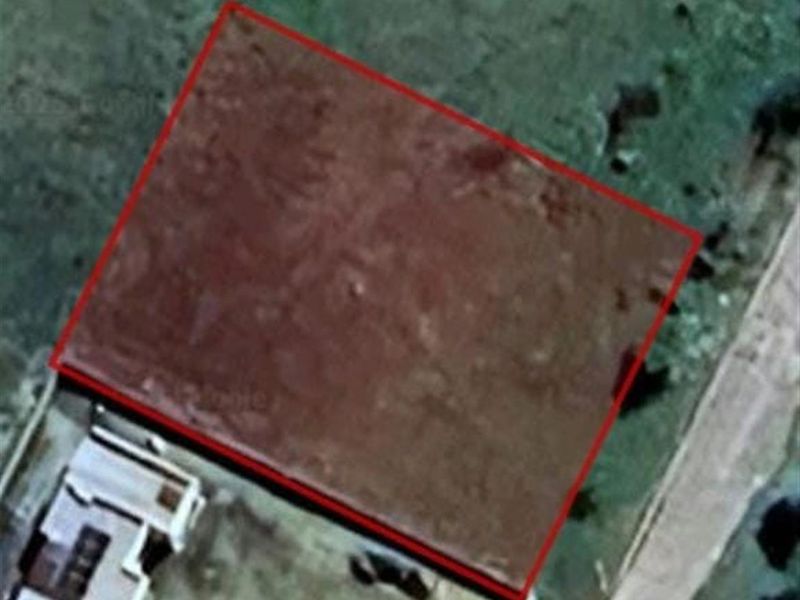 An aerial view showing a vacant residential plot of land with boundary lines highlighted.