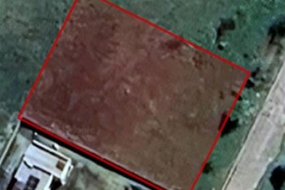 An aerial view showing a vacant residential plot of land with boundary lines highlighted.