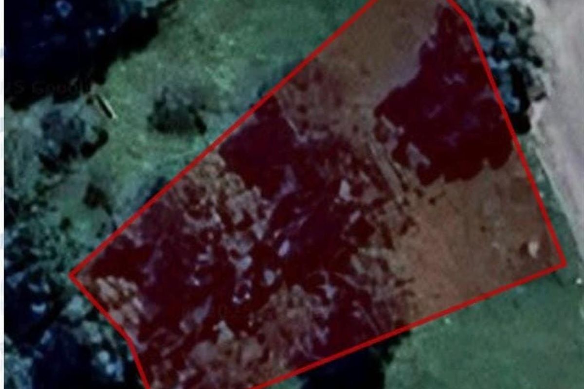 An aerial view showing the boundary of the vacant residential land plot.