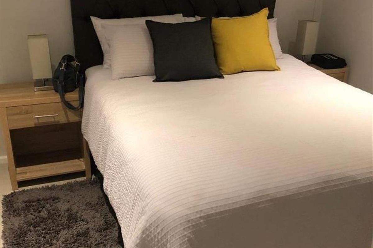 A well-maintained bedroom featuring neutral wall finishes and tiled flooring, providing a clean and comfortable sleeping space.