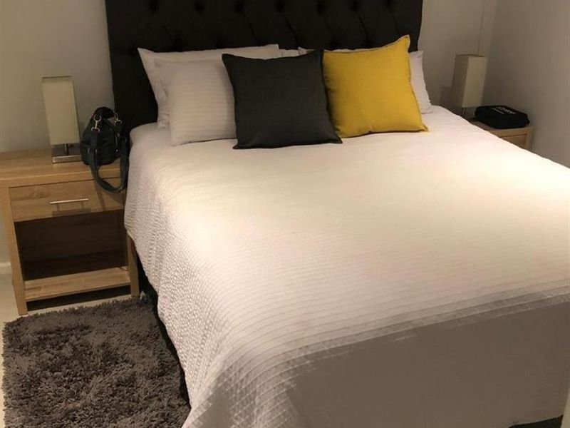 A well-maintained bedroom featuring neutral wall finishes and tiled flooring, providing a clean and comfortable sleeping space.