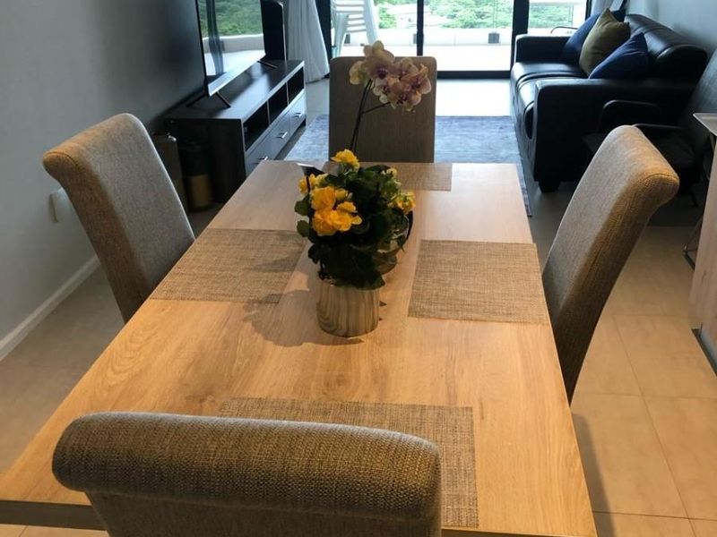 Open plan living and dining area featuring tiled flooring and large sliding glass doors leading to a balcony with scenic views.