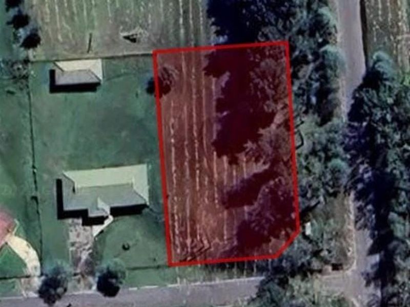 An aerial view of a vacant residential plot highlighting the property boundaries.