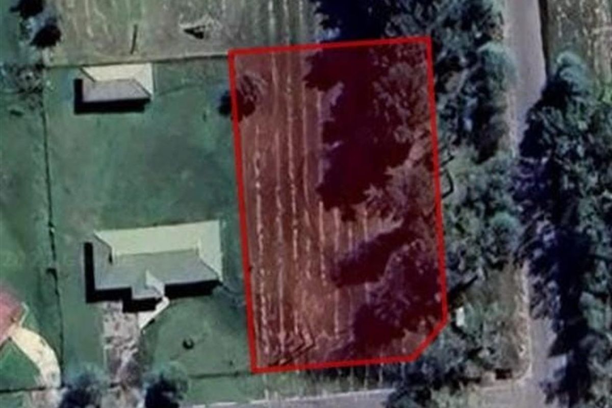 An aerial view of a vacant residential plot highlighting the property boundaries.