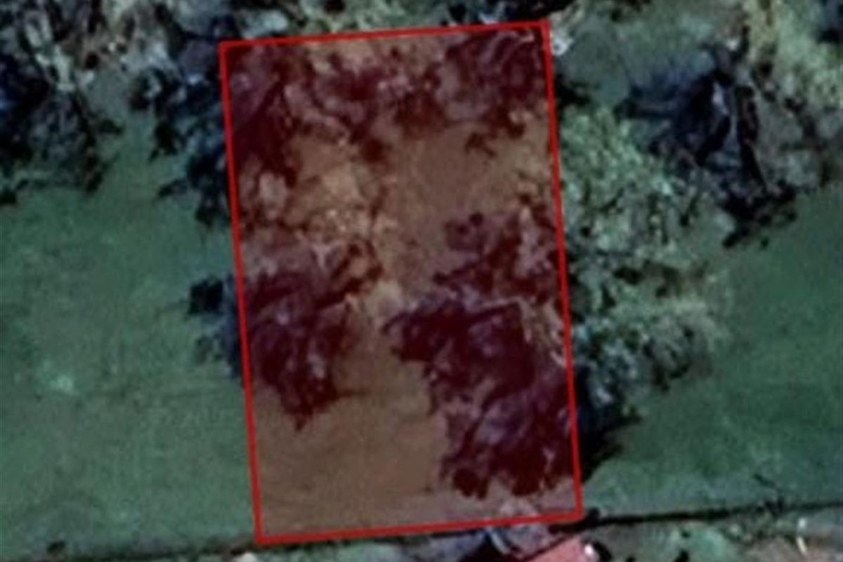 An aerial view showing the boundaries of a vacant residential land parcel.