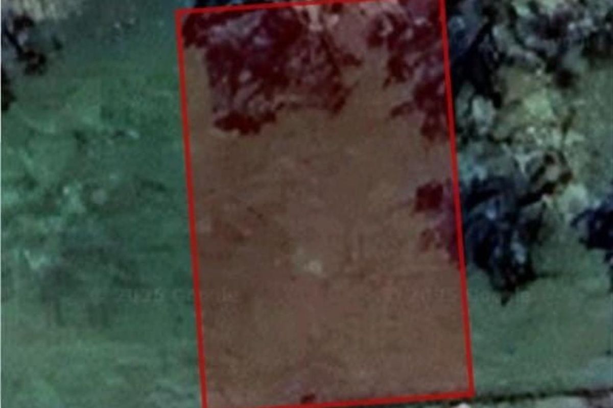 An aerial view showing the boundaries of a vacant residential land parcel.
